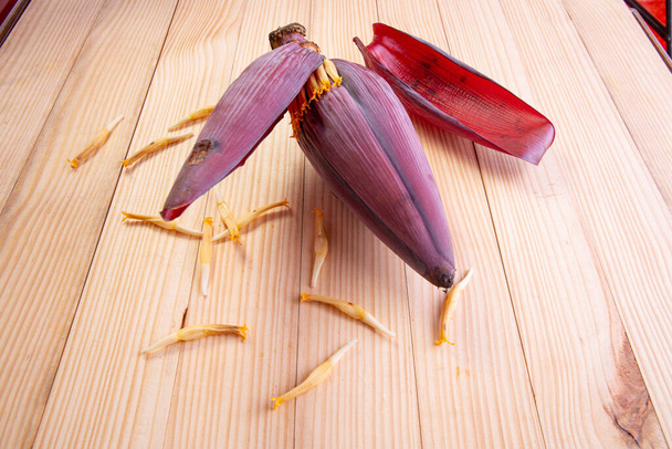 Tuore banaaninkukka tai banaaninkukka, syötävä kasvi, jota käytetään pääasiassa Kaakkois-Aasiassa, puinen kuvioitu pöytä - Valokuva, kuva