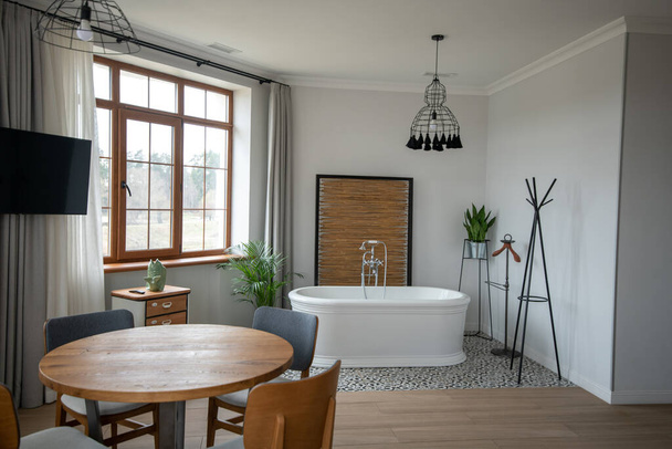 Habitación luminosa con mesa de madera y tubo de lavado - Foto, Imagen