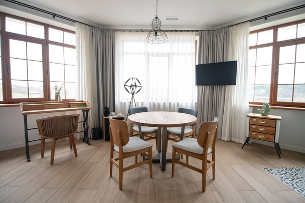 Room with three large windows and round table - Foto, imagen