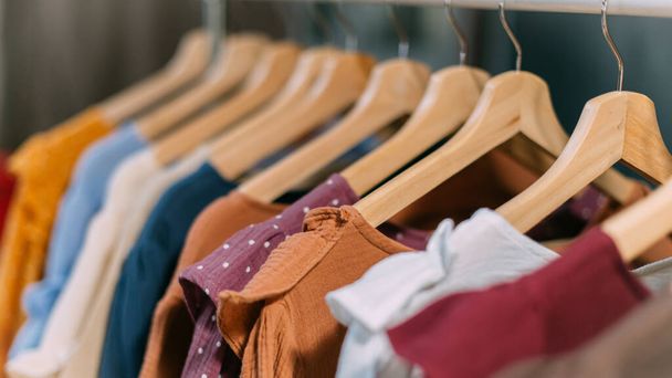 Kleider aus handgefertigten Naturstoffen hängen an einem Kleiderbügel im Geschäft. - Foto, Bild