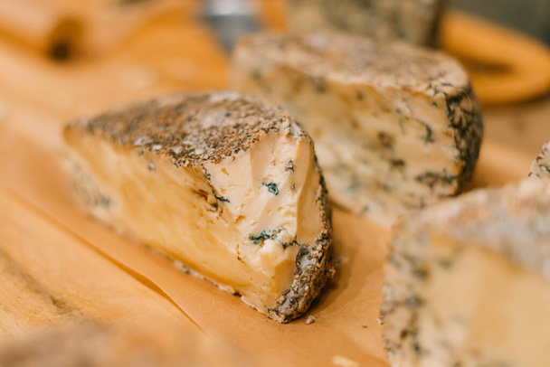 Trozos de queso azul a mano en la muestra del mostrador. - Foto, imagen