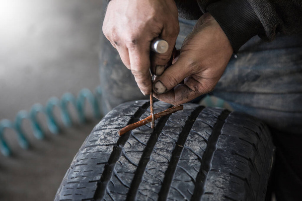 mechanic closes a hole in a tire in a workshop - Fotografie, Obrázek