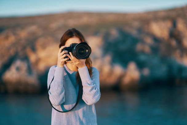 retrato de uma mulher fotógrafa com uma câmera profissional ao ar livre nas montanhas - Foto, Imagem