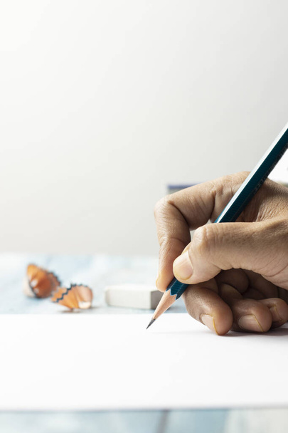 Крупним планом перегляд рук та олівців на папері та білому тлі
 - Фото, зображення
