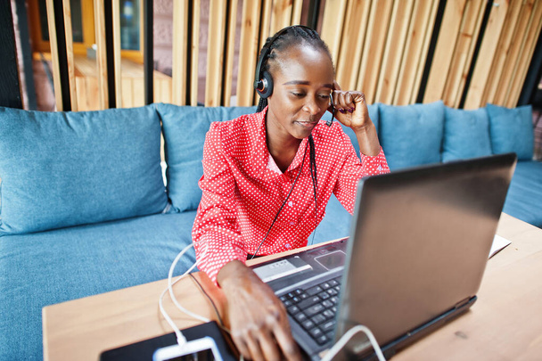 African american woman works in a call center operator and customer service agent wearing microphone headsets working on laptop. - Zdjęcie, obraz