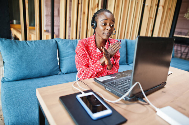 African american woman works in a call center operator and customer service agent wearing microphone headsets working on laptop. - Foto, imagen