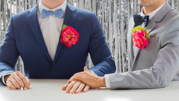 close up of happy male gay couple holding hands - 写真・画像