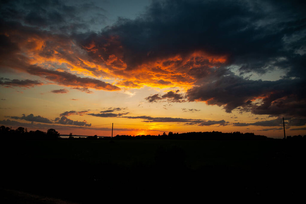 Великолепная панорама сильного восхода солнца с серебристой подкладкой и облаком на оранжевом небе - Фото, изображение