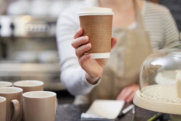 Close Up Of Female Worker in Cafe Serving Coffee In Sustainable Paper Cup - Fotografie, Obrázek