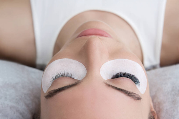 Eyelash Extension Procedure.  Beauty Model with  Perfect Fresh Skin and Long Eyelashes. Slincare, Spa and Wellness. Make up,  Hair and Lashes. Close up. - Foto, Imagen