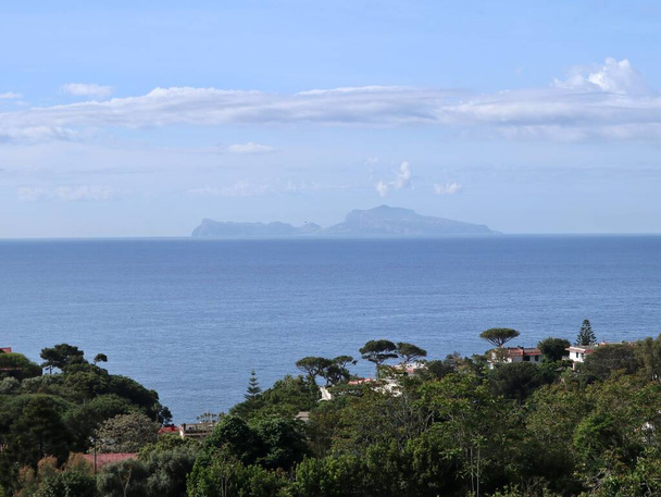 Naples, Campania, Italy - May 20, 2021: Panoramic glimpse of the island of Capri from the Posillipo hill - Фото, изображение