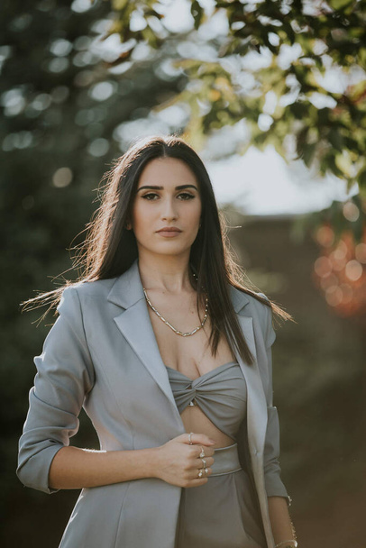 A young sexy Caucasian girl in a grey suit posing in the garden - Foto, Imagem