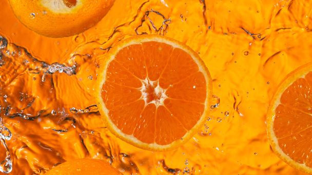 Fresh orange slice falling into splashing water splashing - Fotografie, Obrázek