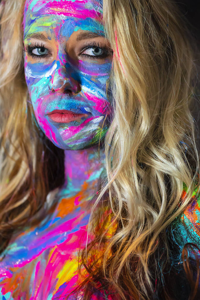 eine nackte Frau wird im häuslichen Umfeld mit bunter Farbe bemalt - Foto, Bild