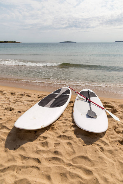 Bílé slunečníky ležící na horkém písku - Fotografie, Obrázek