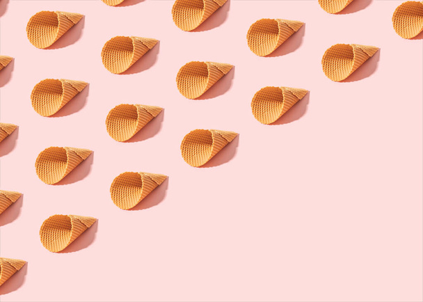 Minimal summer pattern made of empty ice cream cones on sunny pink background.  Diagonal copy space. - Foto, Imagen