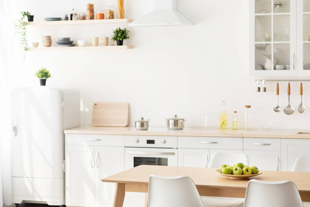 Nový skandinávský design po rekonstrukci. Bílý a dřevěný nábytek s různým nádobím, kuchyňské potřeby - Fotografie, Obrázek