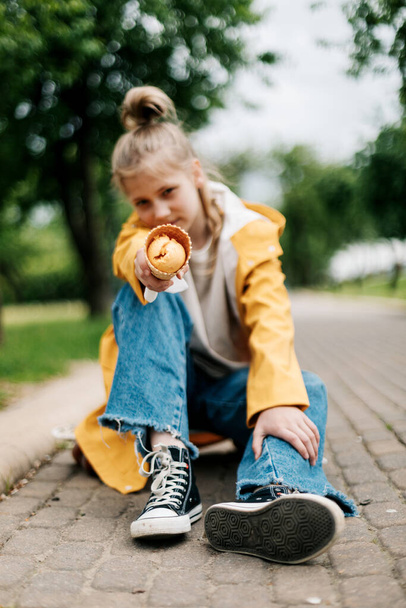 Portrait of a cute blonde teenage girl with ice cream on a walk in the park. Child outdoors - Fotografie, Obrázek