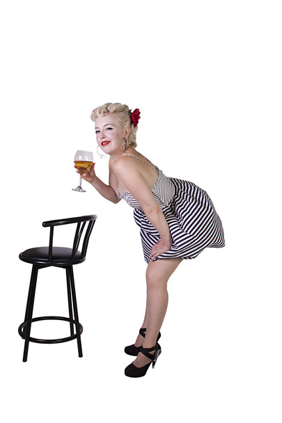 Beautiful pinup retro girl with wine enjoying cool air from fan - Photo, image