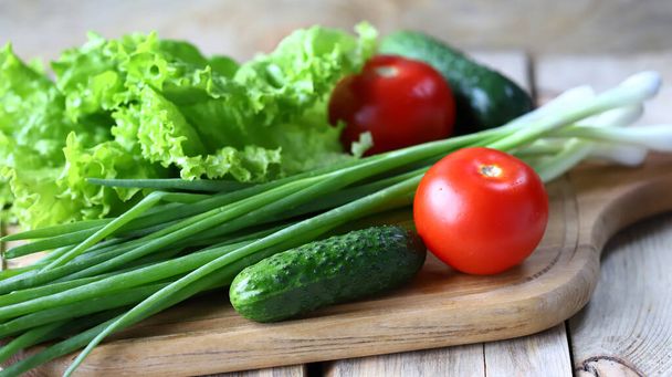 Set van greens op een houten plank. Groene uien, salade, groenten. Gezond dieet. Saladeproducten. - Foto, afbeelding
