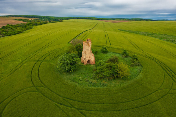 Regoly, Ungarn - Luftaufnahme von Kirchenruinen inmitten eines landwirtschaftlichen Feldes. Ungarischer Name ist Somolyi templomrom - Foto, Bild