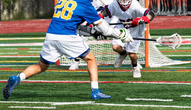 A high schhol boy lacrosse player taking a shot on goal during a game. - Photo, Image