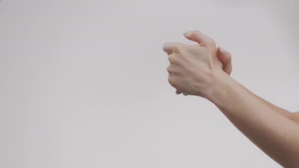 Hautpflege für die Hand. Junge unkenntliche kaukasische Dame cremt Hände ein, massiert Handflächen, Zeitlupe, leerer Raum - Filmmaterial, Video