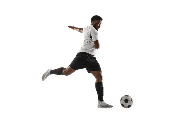 Young African football soccer player training isolated on white background. Concept of sport, movement, energy and dynamic. - Fotó, kép