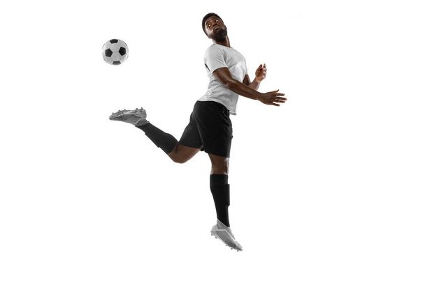One African man football player training isolated on white background. Concept of sport, movement, energy and dynamic. - Photo, Image