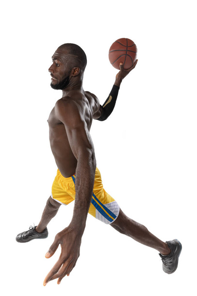 Full length portrait of a basketball player with a ball isolated on white studio background. advertising concept. Fit african american athlete jumping with ball. - Fotó, kép