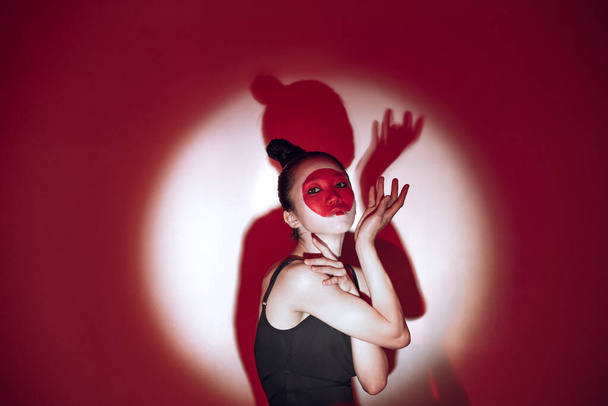 Ballet dancer dancing over red studio background. Modern design. Contemporary colorful conceptual light as rising sun at Japan. - Φωτογραφία, εικόνα
