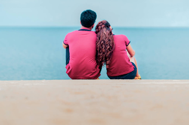 vista trasera de pareja sentada en la playa - Foto, imagen