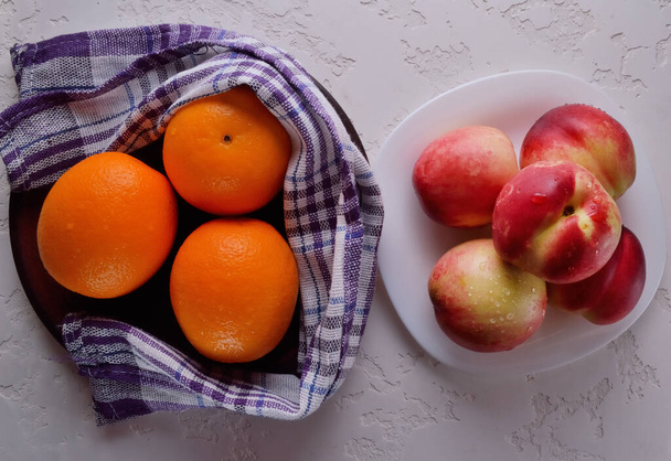 Fresh fruits. Nectarines and oranges on the table. - Valokuva, kuva