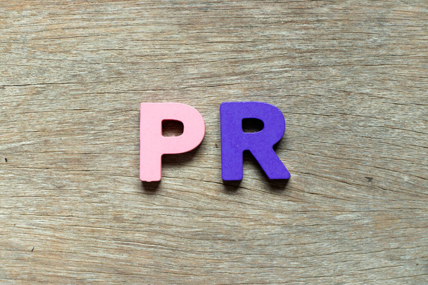 Barevné abecední písmeno ve slově PR (zkratka požadavku na koupi nebo public relations) na dřevěném pozadí - Fotografie, Obrázek