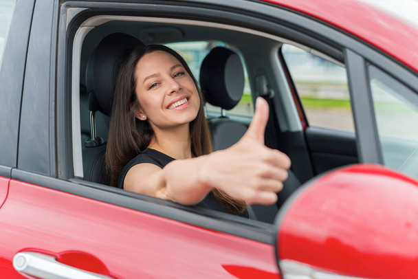 Beautiful woman in the car shows thumbs up. - Valokuva, kuva