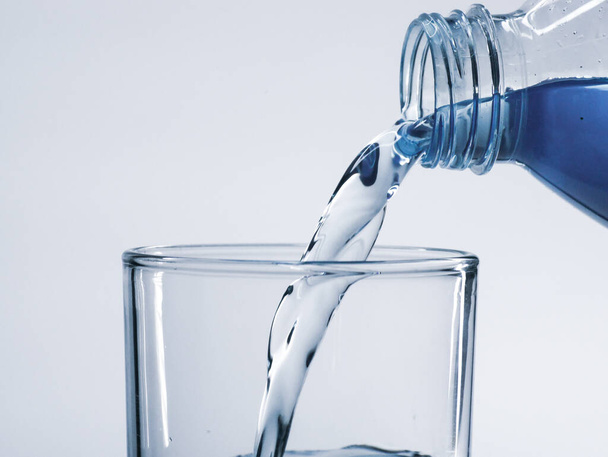Víz öntése üvegből, közelkép - Fotó, kép