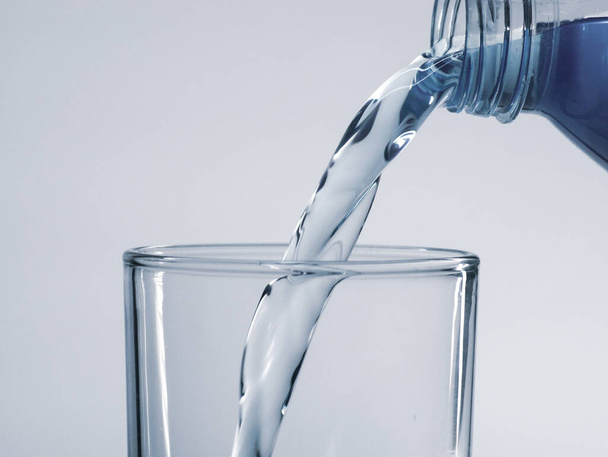 Wasser aus Flasche in Glas gießen, Nahaufnahme - Foto, Bild