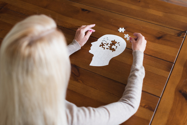 Overhead view of senior woman with dementia folding jigsaw - Photo, Image