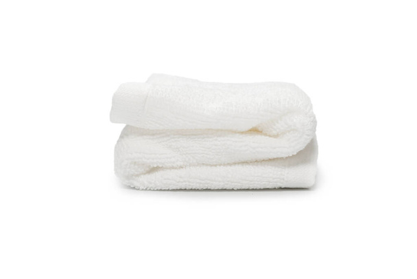 Bílý načechraný bavlněný ručník izolovaný na bílém pozadí. Lázně a resort.  - Fotografie, Obrázek