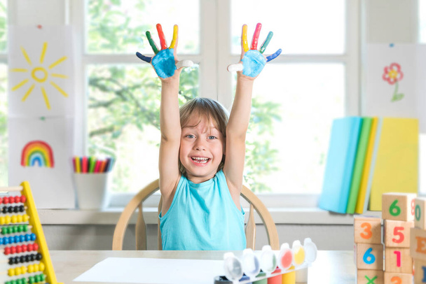 Lustiger Kinderbub zeigt mit Farbe verschmutzte Hände. - Foto, Bild
