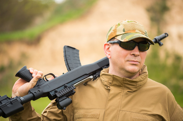 Man in camouflage with a shotgun - Фото, изображение