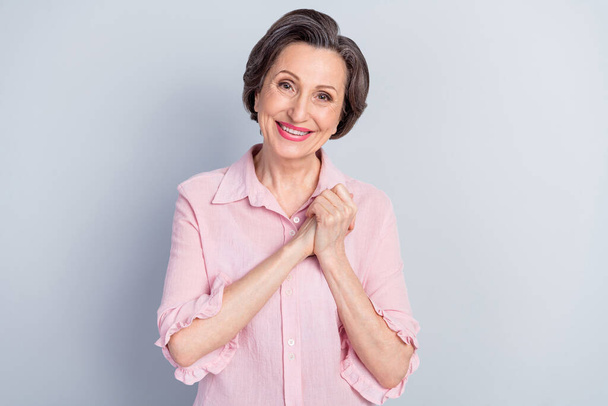 Portrait of attractive pleased glad woman enjoying good news wearing pink shirt isolated over gray pastel color background - Φωτογραφία, εικόνα