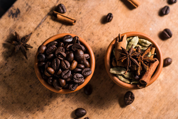 coffee beans on the table and cinnamon.seasonings for coffee cardamom, star anise. - Fotografie, Obrázek