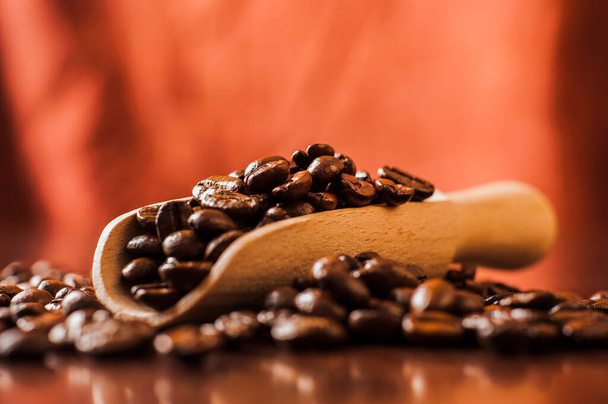 Closeup of coffee beans background.coffee beans on wooden table. Background of ground coffee texture. Coffee beans are scattered on the table. - Фото, зображення