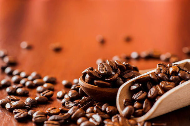 Closeup of coffee beans background.coffee beans on wooden table. Background of ground coffee texture. Coffee beans are scattered on the table. - Fotó, kép