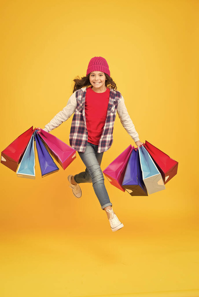 Place where you buy emotions. Energetic shopping addict yellow background. Happy child carry shopping bags. Sale and shopping. Cyber Monday. Black Friday. Shop kids clothing and baby clothes - 写真・画像