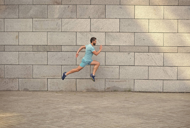Captured in motion jogger man side view, perfect shape concept - Fotó, kép