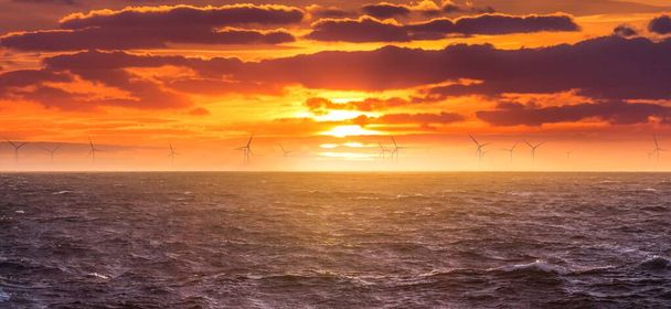 Açık denizde yenilenebilir yeşil elektrik rüzgar enerjisi üretimi. Karbonizasyon endüstrisinde gün doğumu rejeneratif enerjiler için yel değirmeni işi. Temiz enerji yenilenebilir kaynakları iklim değişikliğini önlemektedir. - Fotoğraf, Görsel