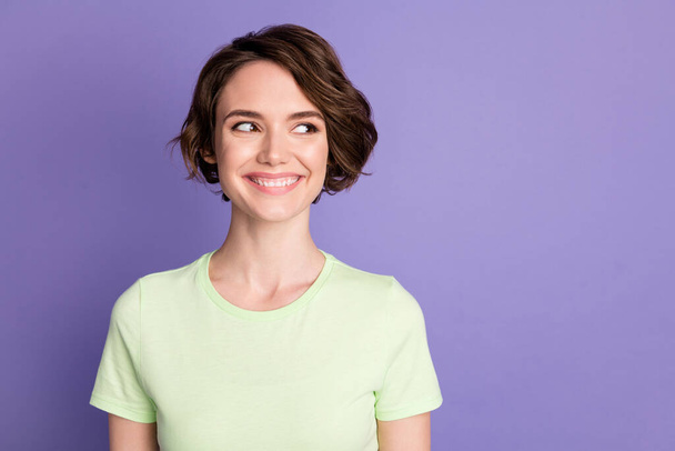 Portrait of attractive cheerful brown-haired girl looking aside copy empty blank space ad isolated over violet color background - Foto, immagini