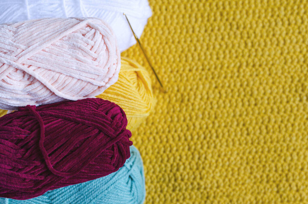 濃い木製の背景に色糸と編み物の皮は自己分離の編み物の概念を背景に針仕事をしている - 写真・画像